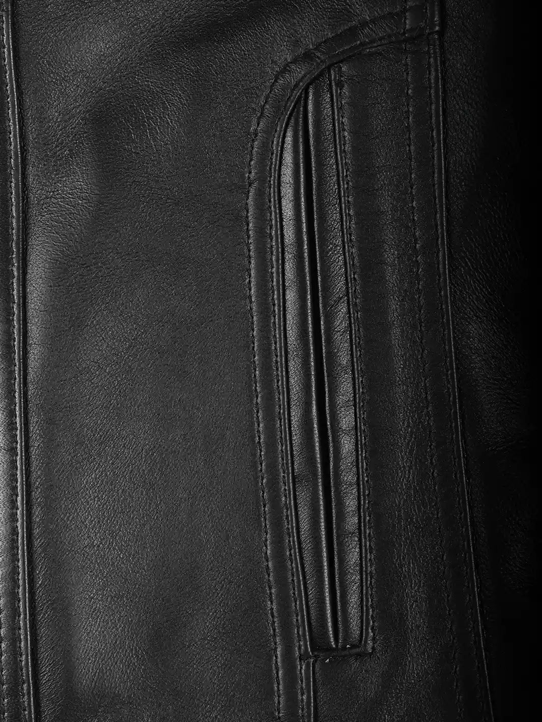 Close-up of black leather texture with stitching details.